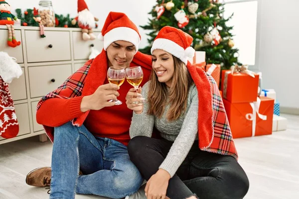 크리스마스 모자를 담요를 바닥에 앉아서 샴페인을 집에서 마시며 건배를 — 스톡 사진