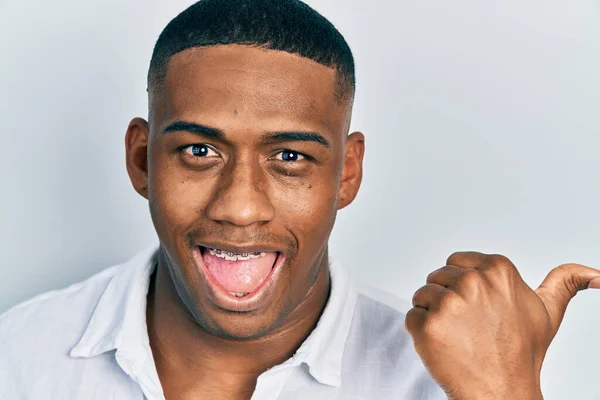Jonge Zwarte Man Geïsoleerde Achtergrond Wijzen Duim Naar Zijkant Glimlachen — Stockfoto