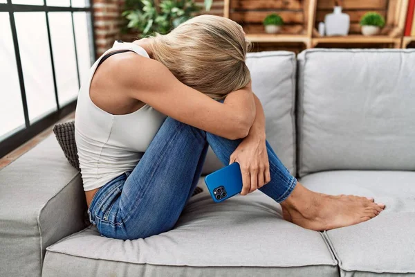 Young Blonde Woman Depressed Using Smartphone Home — 스톡 사진