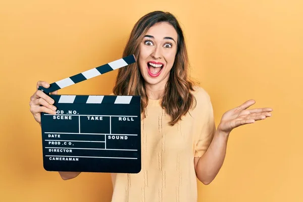 Young Hispanic Girl Holding Video Film Clapboard Celebrating Achievement Happy — Stockfoto