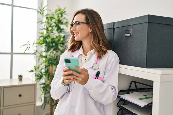 Mujer Joven Vistiendo Uniforme Médico Usando Teléfono Inteligente Clínica —  Fotos de Stock