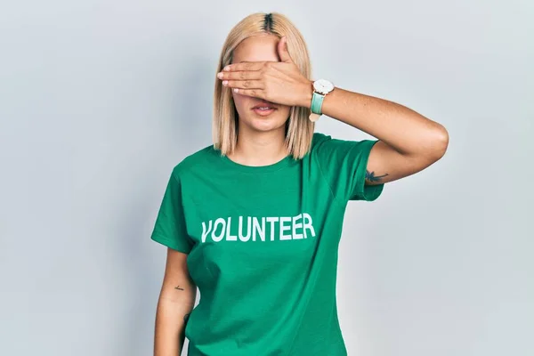 Beautiful Blonde Woman Wearing Volunteer Shirt Covering Eyes Hand Looking —  Fotos de Stock