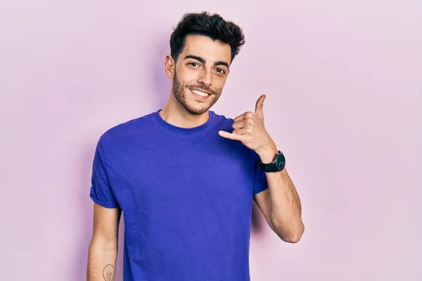 Günlük Tişört Giyen Genç Spanyol Adam Gülümsüyor Telefonla Parmak Hareketleri — Stok fotoğraf