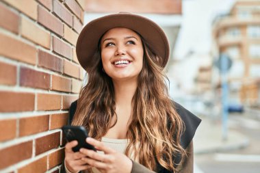 Şehirde akıllı telefon kullanan genç İspanyol turist kadın..