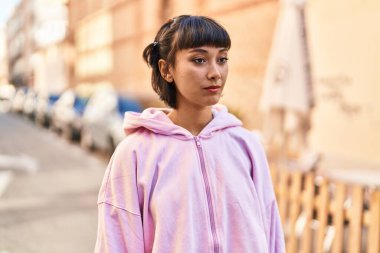 Sokakta rahat bir ifadeyle duran genç kadın.