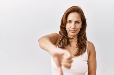 Orta yaşlı İspanyol bir kadın izole edilmiş bir geçmişin başında mutsuz ve kızgın bir şekilde duruyor. Reddedilmiş ve olumsuz hareketler sergiliyor. kötü ifade. 