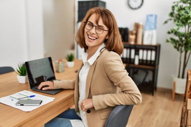 Ofiste çalışırken gülümseyen beyaz bir iş kadını..