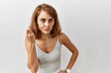 Güzel beyaz kadın izole edilmiş arka planda duruyor. İtalyan jestleri yapıyor. Elleri ve parmakları kendinden emin bir ifadeyle. 