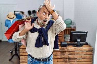 Butik dükkanında alışveriş torbaları tutan yakışıklı bir adam. Hatayla el ele şaşırmış. Hatayı hatırla. Unuttum, kötü hafıza kavramı. 