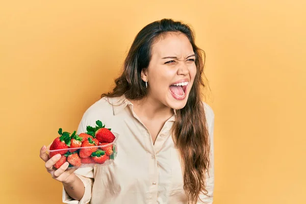 Joven Chica Hispana Sosteniendo Fresas Enojadas Locas Gritando Frustradas Furiosas —  Fotos de Stock