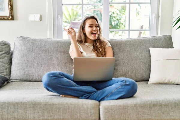 Kanepede oturan genç, güzel esmer kadın. Evde bilgisayarını kullanıyor. Gülümsüyor, kameraya göz kırpıyor ve zafer işareti yapıyor. İki numara.. 