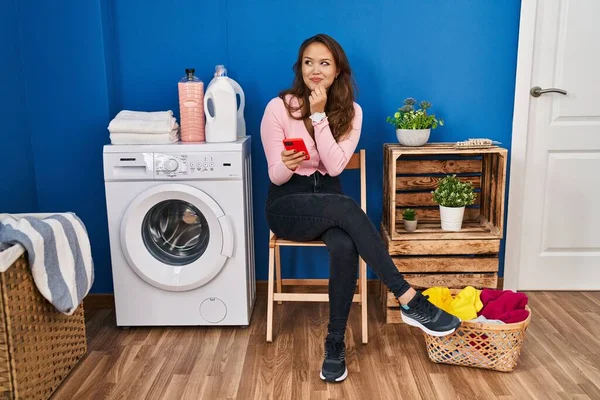 Mujer Hispana Joven Sentada Esperando Lavandería Usando Smartphone Con Mano —  Fotos de Stock