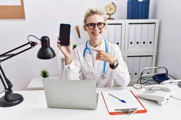 Young Doctor Woman Holding Smartphone Showing Blank Screen Smiling Happy — Foto de Stock