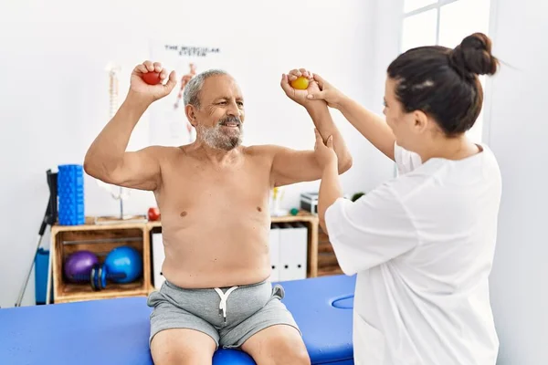 理疗师和微笑自信的病人在诊所使用电球进行康复治疗 — 图库照片