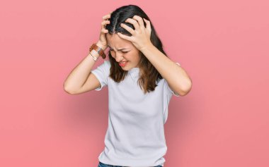 Genç, güzel bir kadın, günlük beyaz tişört giyiyor. Baş ağrısı, çaresiz ve stresli. Çünkü ağrı ve migren ağrısı var. Eller başının üstünde.. 