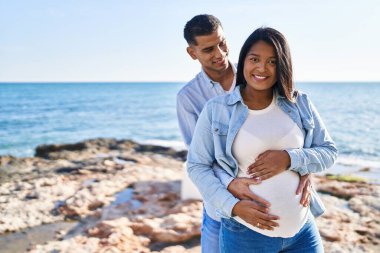 Genç, Latin bir çift bebek bekliyor. Birbirlerine sarılıyorlar.