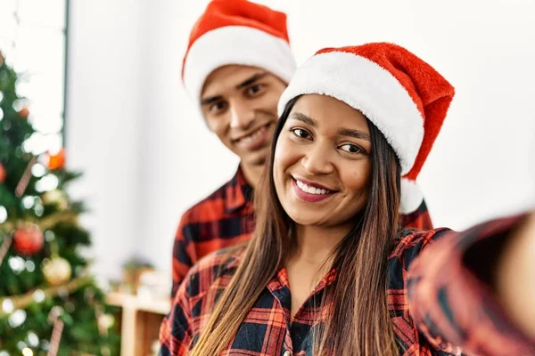 Young Latin Couple Wearing Christmas Hat Making Selfie Smartphone Home — Stock Fotó