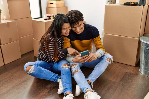 Jeune Couple Latin Utilisant Smartphone Assis Sur Sol Maison Neuve — Photo