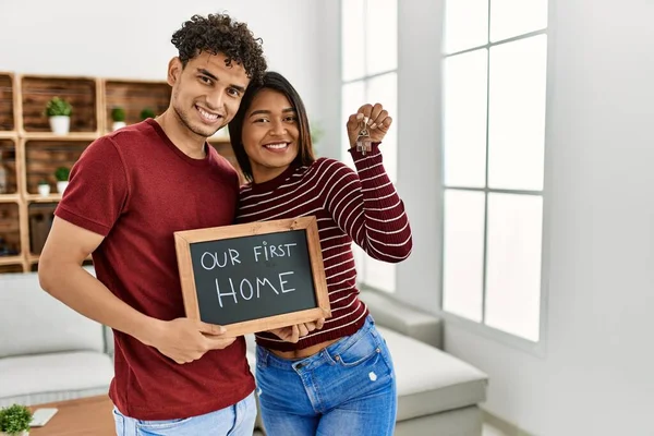 Young Latin Couple Smiling Happy Holding Our First Home Blackboard — Φωτογραφία Αρχείου