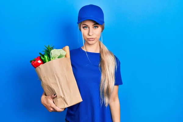 Young Caucasian Woman Wearing Courier Uniform Groceries Supermarket Relaxed Serious — Stockfoto