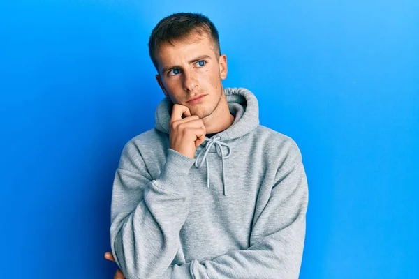 Young Caucasian Man Wearing Casual Sweatshirt Thinking Concentrated Doubt Finger —  Fotos de Stock