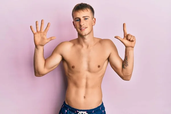 Young Caucasian Man Wearing Swimwear Showing Pointing Fingers Number Seven — Stockfoto