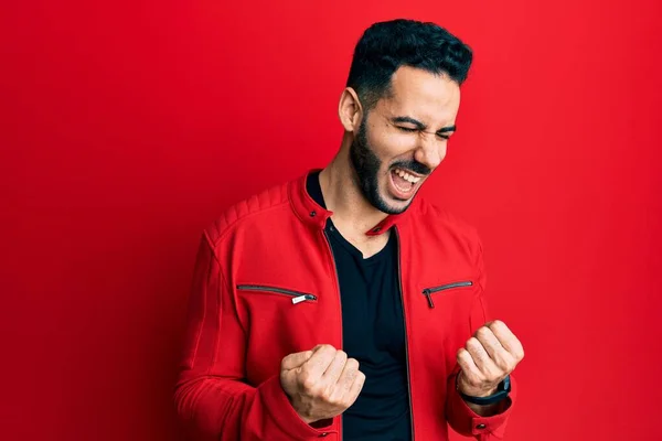Ung Latinamerikansk Man Bär Rött Läder Jacka Firar Förvånad Och — Stockfoto