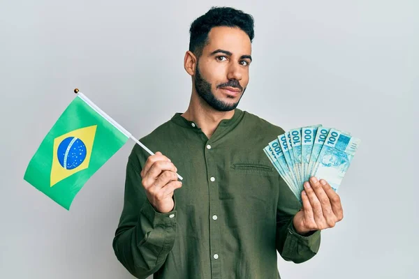 Mladý Hispánec Drží Brazilskou Vlajku Skutečné Bankovky Usmívají Dívají Stranou — Stock fotografie