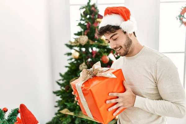 Young Hispanic Man Smiling Happy Holding Gift Home — ストック写真