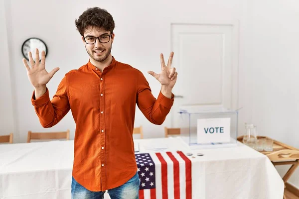 Hispanic Man Standing Election Room Showing Pointing Fingers Number Eight — Stockfoto