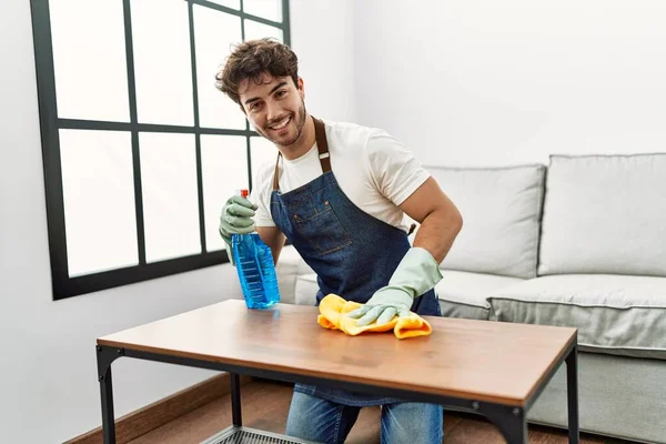 Νεαρός Ισπανός Άντρας Χαμογελάει Αυτοπεποίθηση Καθαρίζοντας Τραπέζι Στο Σπίτι — Φωτογραφία Αρχείου