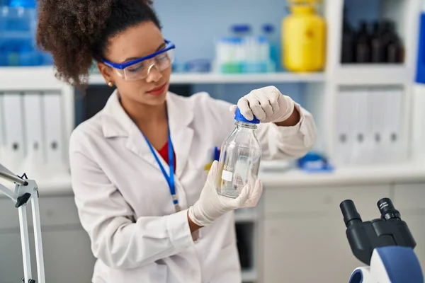 在实验室里穿着科学家制服的年轻的非洲裔美国女人 — 图库照片