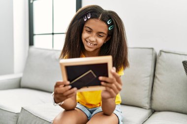 Afro-Amerikalı kız gülümseyerek evde kendine güvenen bir resim görüyor.