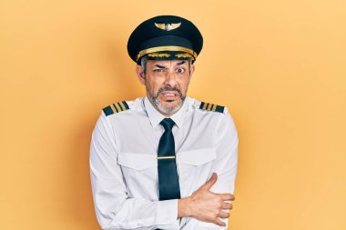 Yakışıklı, orta yaşlı, gri saçlı, uçak pilotu üniforması giyen, kışın soğuktan titriyor ve donuyor. Yüzünde üzgün ve şok ifadesi var. 