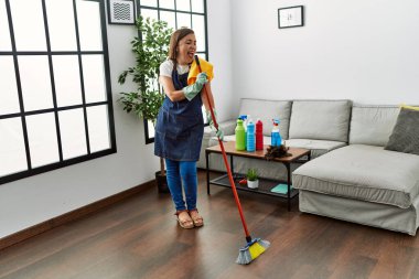 Orta yaşlı İspanyol kadın evde hizmetçi olarak dans ediyor.