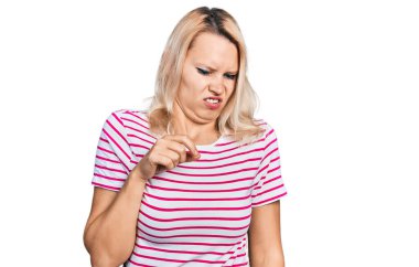 Kafkasyalı genç bir kadın günlük giysiler giyiyor, tiksindirici bir ifade takınıyor, tiksindirici bir yüz ifadesi takınıyor ve tiksindirici bir ifade takınıyor.. 