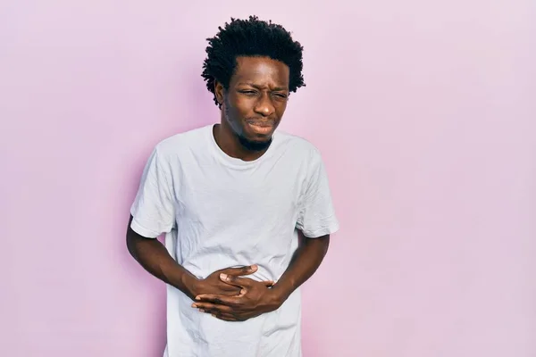 消化不良 痛みを伴う病気が具合が悪いので 若いアフリカ系アメリカ人男性は胃の上に手でカジュアルな白いTシャツを着ています キャッシュ コンセプト — ストック写真