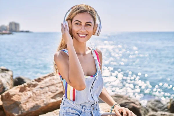 Mladá Blondýna Dívka Poslouchá Hudbu Sedí Skále Pláži — Stock fotografie