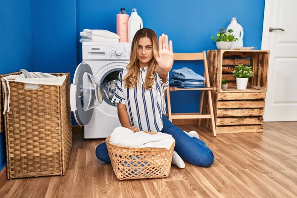 Young Blonde Woman Doing Laundry Home Open Hand Doing Stop — Stok fotoğraf