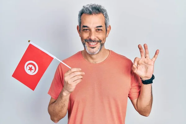 Hezký Muž Středního Věku Šedými Vlasy Drží Tuniskou Vlajku Dělá — Stock fotografie