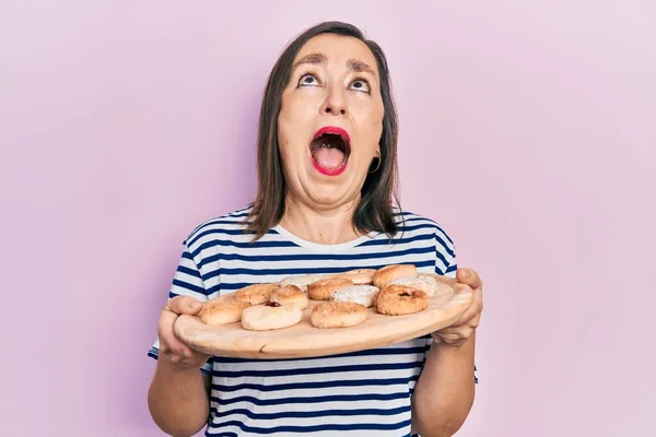 Middle Age Hispanic Woman Holding Sweet Pastries Angry Mad Screaming — Zdjęcie stockowe