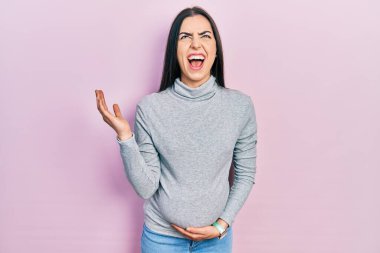 Mavi gözlü güzel bir kadın bebek bekliyor hamile karnına dokunuyor deli deli deli bağırıyor ve agresif bir ifadeyle bağırıyor ve kollarını kaldırıyor. hüsran kavramı. 