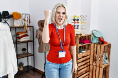 Perakende mağazasında yönetici olarak çalışan genç beyaz bir kadın kızgın ve kızgın yumruğunu kaldırıyor ve öfkeyle bağırıyor. öfke ve agresif konsept. 