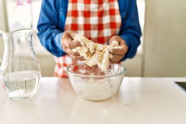 Son sınıf öğrencisi mutfakta hamur pişiriyor.