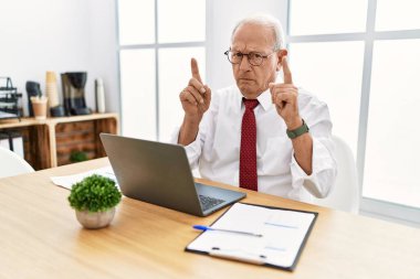 Ofiste çalışan kıdemli bir adam bilgisayarı kullanarak üzgün ve üzgün görünüyor, parmaklarıyla yön gösteriyor, mutsuz ve depresif.. 