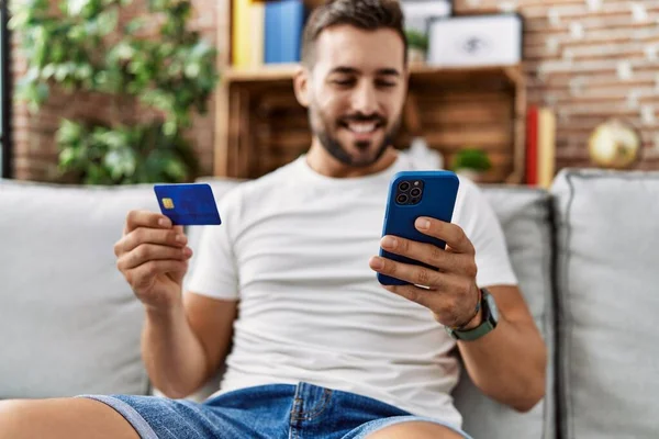 Giovane Uomo Ispanico Sorridente Fiducioso Utilizzando Smartphone Carta Credito Casa — Foto Stock