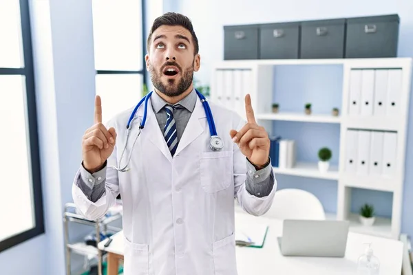 Handsome Hispanic Man Wearing Doctor Uniform Stethoscope Medical Clinic Amazed — Stockfoto