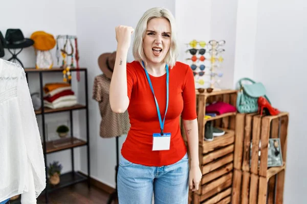 Perakende mağazasında yönetici olarak çalışan genç beyaz bir kadın kızgın ve kızgın yumruğunu kaldırıyor ve öfkeyle bağırıyor. öfke ve agresif konsept. 