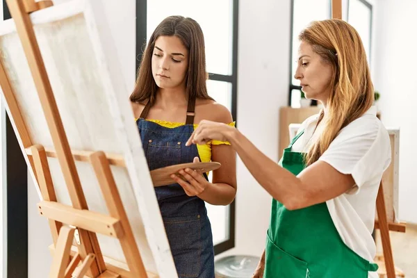 Anne ve kızı resim stüdyosunda resim çiziyor.