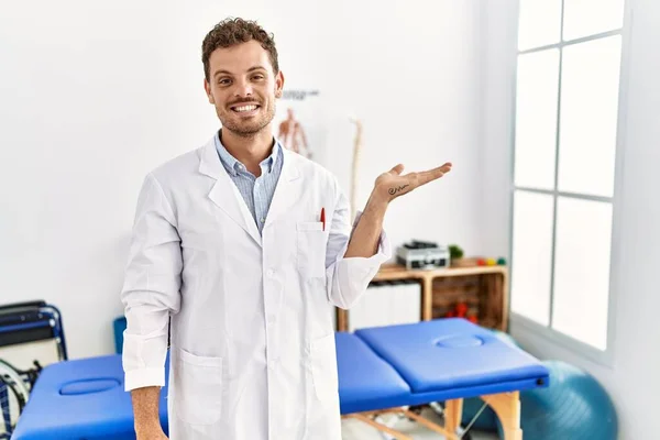 Handsome Young Man Working Pain Recovery Clinic Smiling Cheerful Presenting — Stok fotoğraf